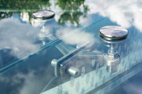 Stainless steel spider glass fitting, glass building facade modern architecture closeup.