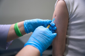 Patient in the clinic receives an injection in the arm