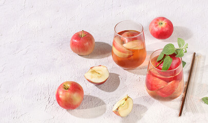 Apple cider, juice or fruit drink in a glass on a sunny table, autumn vitamin mulled wine with...