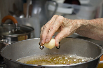 Grandmother's hands cooking traditional colombian round fritters, freshly made at home, snack and typical Colombian breakfast.