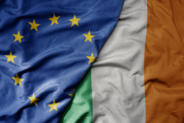 big waving realistic national colorful flag of european union and national flag of ireland .