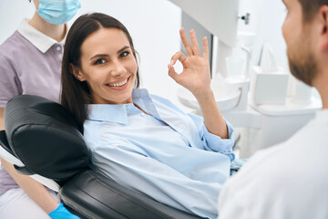 Positive woman client enjoying good service in private dental clinic, routine check-up - obrazy, fototapety, plakaty