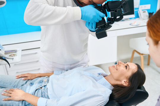 Qualified doctor making image of client teeth to determine size of problem