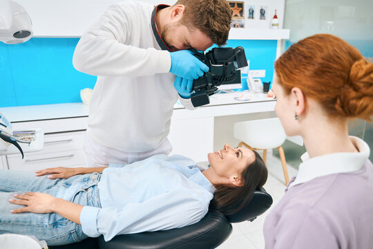 Dental technician doing image of teeth using portable x-ray camera
