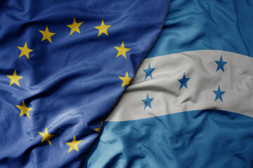 big waving realistic national colorful flag of european union and national flag of honduras .