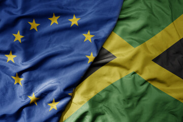 big waving realistic national colorful flag of european union and national flag of jamaica .