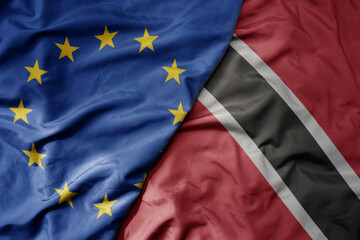 big waving realistic national colorful flag of european union and national flag of trinidad and...