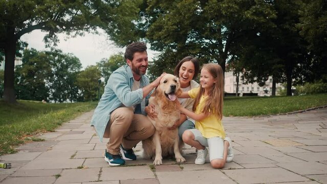 Happy family rejoices stroking dog and spending time on walk