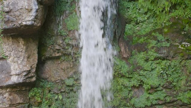 Waterfall in the mountains. Water falls from the rock. Waterfall Giessen, Canton Baselland, Switzerland.