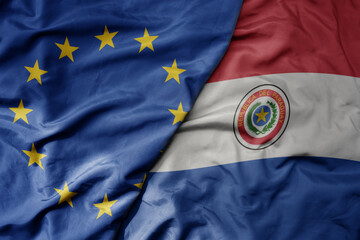 big waving realistic national colorful flag of european union and national flag of paraguay .