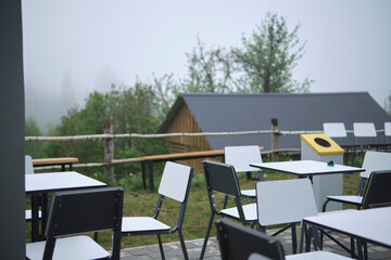 White tables and chairs are ready to receive guests outdoors