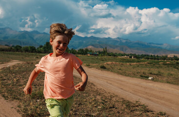 Happy boy running on mountains background - 628694904