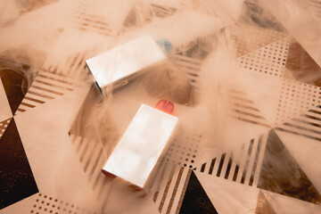 Two pods with different colored spikes with smoke in the background on a table.