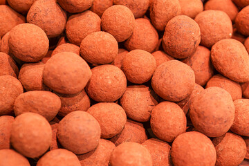 Chocolate candies in the form of balls, close-up . Chocolate truffles for sale in a market
