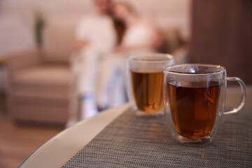 Hot tea is cooling down on the table in the room