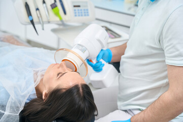 Dentist holds in his hands special lamp for photopolymer fillings