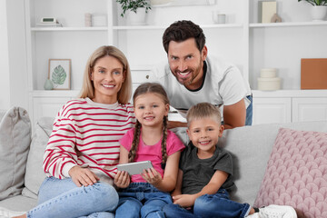 Happy family with smartphone spending time together on sofa at home