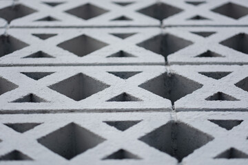 A wall built out of breeze blocks, forming a pattern of squares and triangles that fades away into...