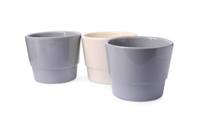 Different empty ceramic flower pots on white background