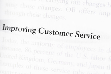 Business textbook with the importance of improving customer service focused in closeup of explanation	