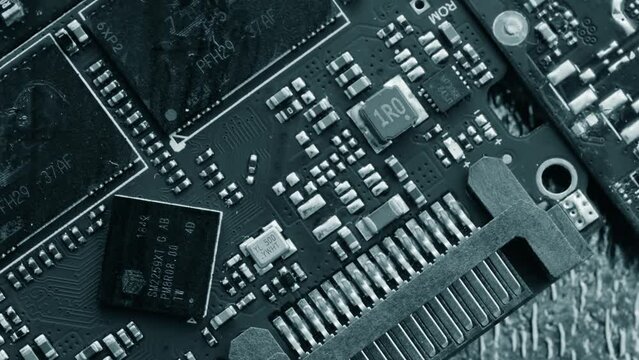 Chips and microcircuits background, different types circuits in black and white colors lie on table rotate, close up. Computer motherboard components shot.