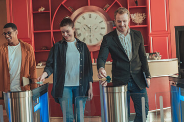 Group of people pass through the office entrance gate after ID card authentication