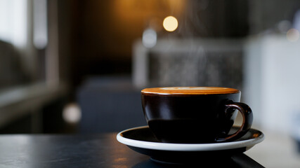 A cup of cappuccino coffee with soft foam on a wooden table. The coffee moment concept is everywhere.