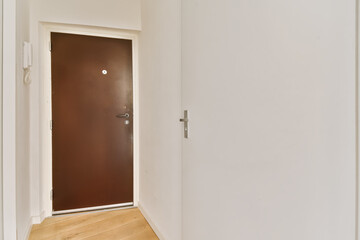 an empty room with white walls and wood flooring the door is open to let in light into the room