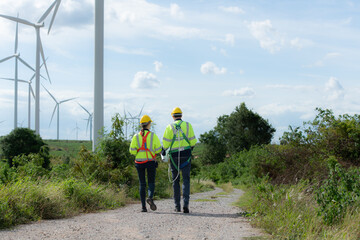 Engineers and wind turbines in a wind farm in the countryside with daily audit tasks mission