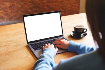 Mockup image of a woman using and typing on laptop computer with blank white desktop screen