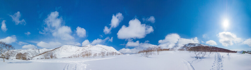 Snow covered mountains and fields with ski tracks and footprints (Niseko, Hokkaido, Japan)