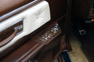 Close up of luxury car door panel. Interior of prestige classic sports car. White and brown leather...