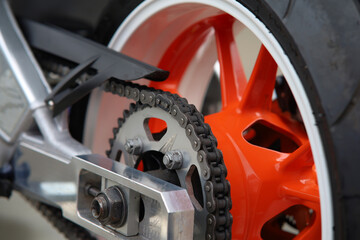 Detail of a motorcycle wheel, swingarm, sprocket and rear drive chain transmitting engine power