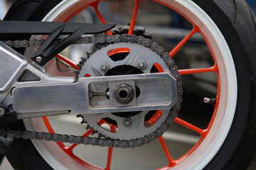 Fototapeta premium Detail of a motorcycle wheel, swingarm, sprocket and rear drive chain transmitting engine power