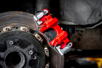 Car mechanic or serviceman disassembly and checking a disc brake and asbestos brake pads for fix...