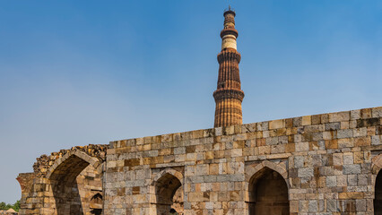 Ruins of the ancient temple complex Qutub Minar. A dilapidated brick wall with arches. The world's...