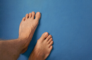 Pies de hombre joven, descalzo, dedos, uñas y tobillo. Salud, podología y vena variz.  © Will Labrador