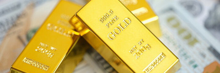 Close up of gold bars on many US dollar bills.
