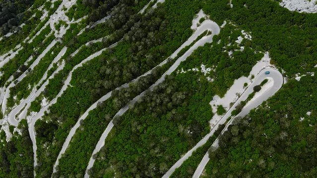 Vertical serpantine road in mountain with green forest. Aerial View