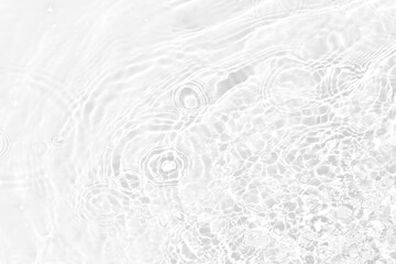 White water with ripples on the surface. Defocus blurred transparent white colored clear calm water surface texture with splashes and bubbles. Water waves with shining pattern texture background.