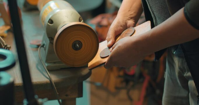 craftsman polishing the serface of leather material Masterclass, workshop session Slow motion, artisan gives product a professional look