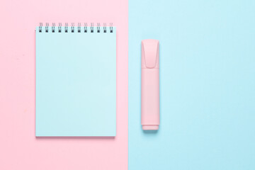 Notebook with a marker on a blue-pink background. Top view