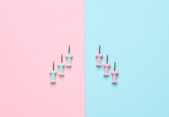 Stationery pins on a pink blue pastel background.