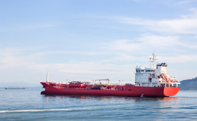 A red ship with drilling equipment leaving the port