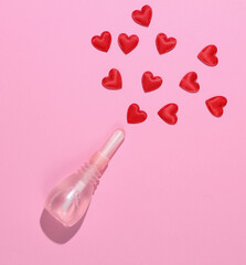 Vaginal enema with hearts on a pink background. Women's health