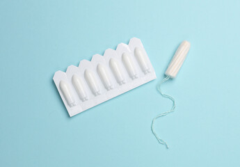 Women's health, treatment of women's diseases. Vaginal suppositories and tampon on blue background. Flat lay