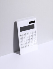 White calculator on white gray background with shadow. Business and finance concept. Creative layout