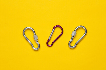 Metal carabiners on a yellow background