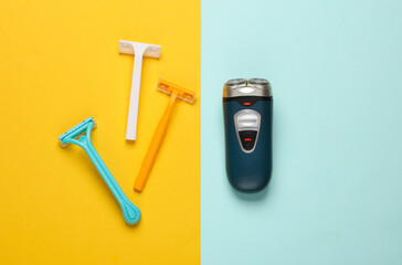 Razors and electric shaver on colored paper background. Beauty concept. Top view