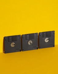 Outdated technologies. Retro 80s floppy disks on yellow background with shadow. Creative layout